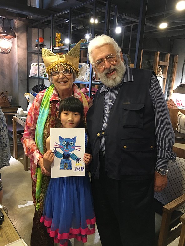 Cristina Làstrego e Francesco Testa con una giovane lettrice che mostra un disegno di Gatto Mirò